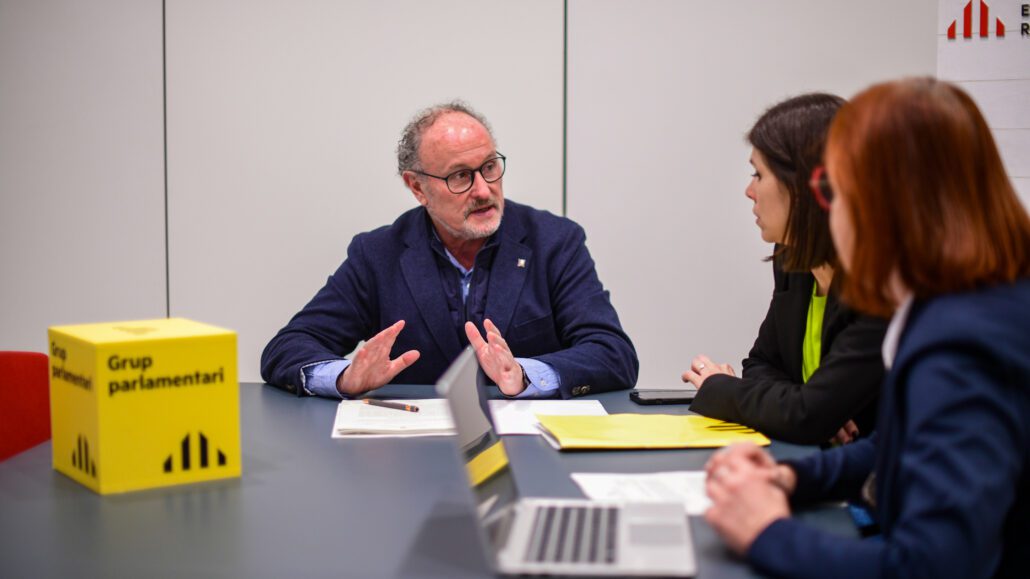 Tres persones assegudes al voltant d'una taula