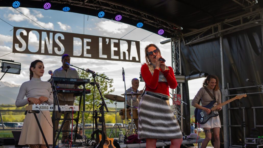 Grup de persones, en un escenari cantant i tocant instruments