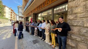 Diverses persones a les portes d'un edifici, amb una cinta a les mans