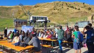 Gent asseguda a unes taules en una estació de muntanya