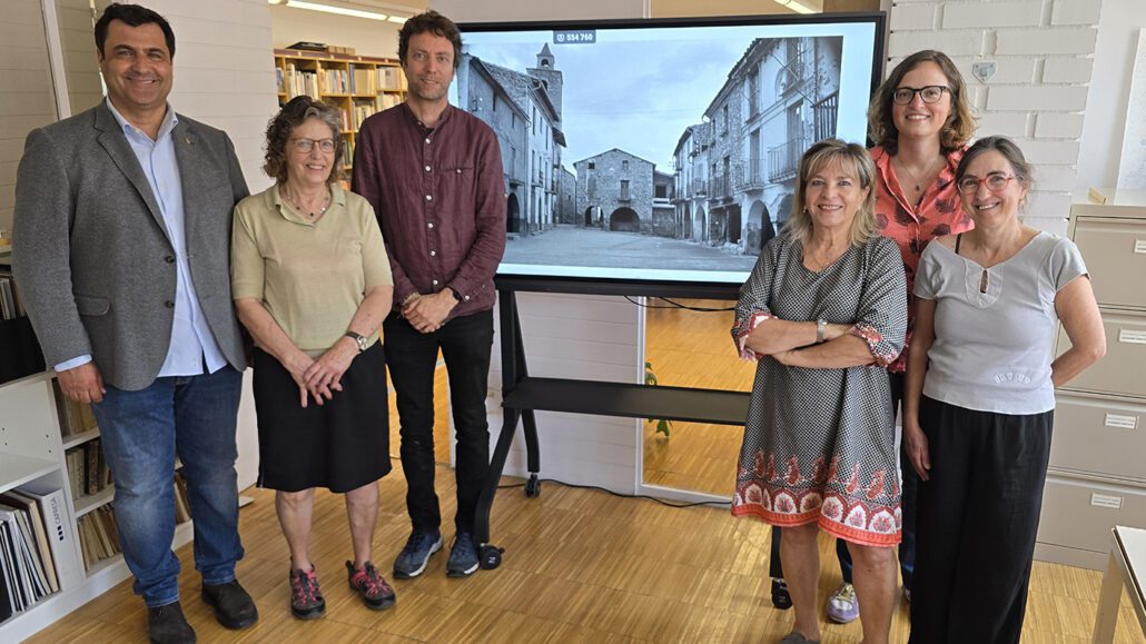 Sis persones davant una fotografia en blanc i negre