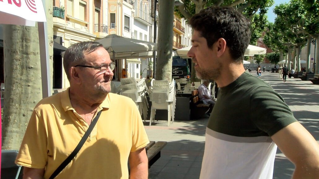 Dos homes xerrant al carrer