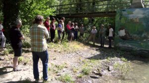 Persones davant un mural on hi ha un ocell pintat