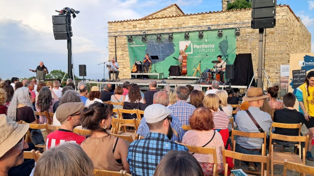Gent assistent a un concert en un espai obert